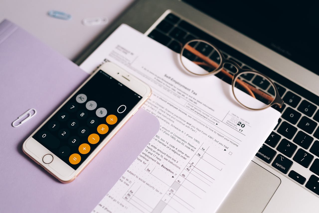 a computer, glasses, tax document and calculator